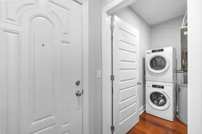 a white laundry room with a washer and dryer at Luxury Studio Loft - Rooftop View & Pool in Philadelphia