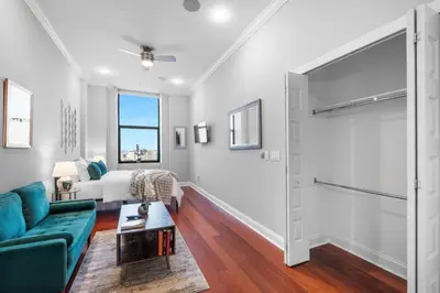 a living room with a couch and a tv at Luxury Studio Loft - Rooftop View & Pool in Philadelphia