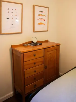 a wooden dresser in a bedroom with a bed at Hot Tub, Wood-burning Fireplace and 4 acres of Forest in Margaretville in Margaretville