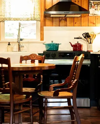 a kitchen with a table and chairs and a stove at Hot Tub, Wood-burning Fireplace and 4 acres of Forest in Margaretville in Margaretville