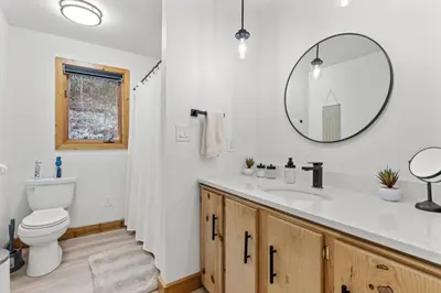a bathroom with a sink and a toilet and a mirror at Pine Hollow Lodge in Duncannon