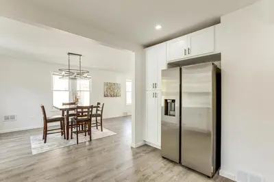 a kitchen and dining room with a table and a refrigerator at Walk to River, Parks and Dining Family Home with Yard