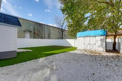 a house with a white fence and a shed at Walk to River, Parks and Dining Family Home with Yard