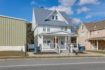 a white house with a porch on a street at Walk to River, Parks and Dining Family Home with Yard