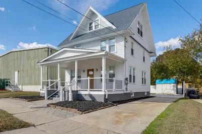 a white house with a porch on a street at Walk to River, Parks and Dining Family Home with Yard