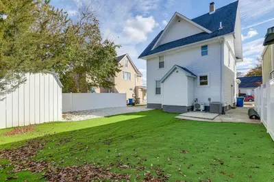 a white house with a blue roof and a yard at Walk to River, Parks and Dining Family Home with Yard
