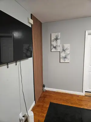 a room with a white wall with two pictures on it at Entire Spacious House in New Jersey in East Orange