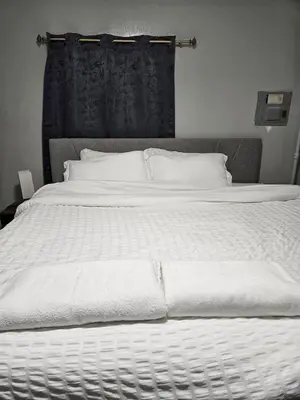 a large white bed with white sheets and pillows at Entire Spacious House in New Jersey in East Orange