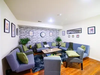 a living room with blue couches and a table at Bright Private Room with Shared Bathroom near NYC in Jersey City