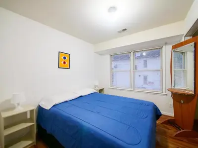 a bedroom with a blue bed and two windows at Charming Private Room in a Friendly Home mins to NYC in Jersey City