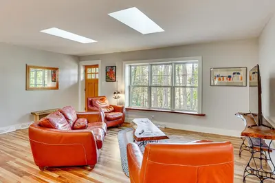 a living room with orange leather furniture and windows at Serene Getaway with Trail Access in Chester Springs in Chester Springs