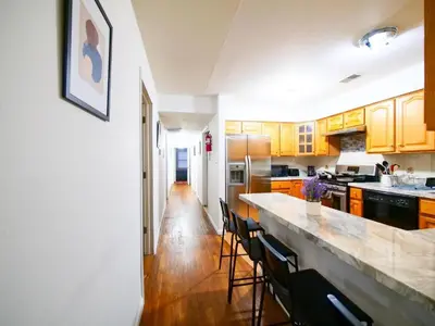 a kitchen with wooden cabinets and a counter top at Mins to NYC Comfy Private Room in Shared Home in Jersey City