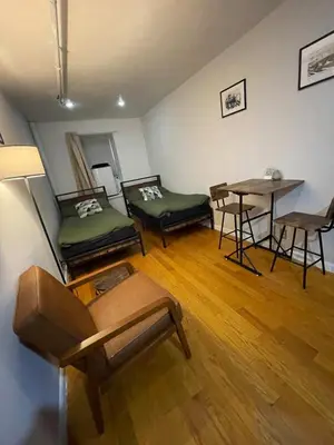 a room with two beds and a table in it at Union Square Studio with Kitchen -Shared Bathroom in New York