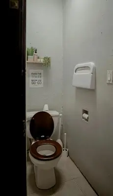 a bathroom with a toilet with a wooden seat at Union Square Studio with Kitchen -Shared Bathroom in New York
