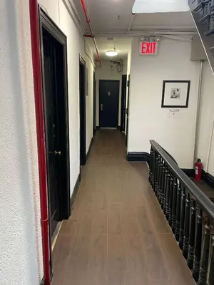 an empty hallway with a exit sign on the wall at Union Square Studio with Kitchen -Shared Bathroom in New York