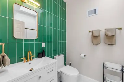 a green tiled bathroom with a sink and a mirror at Elegant Home w Patio | In-Unit Laundry Near NYC in Jersey City