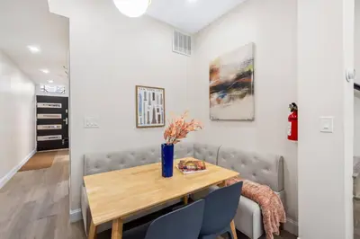 a dining room with a table and a couch at Elegant Home w Patio | In-Unit Laundry Near NYC in Jersey City