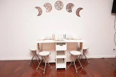 a table with stools in a room with a wall at West Village Escape - Steps from Subway Cafes in New York