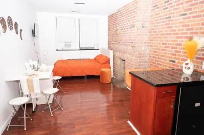 a room with a bed and a brick wall at West Village Escape - Steps from Subway Cafes in New York