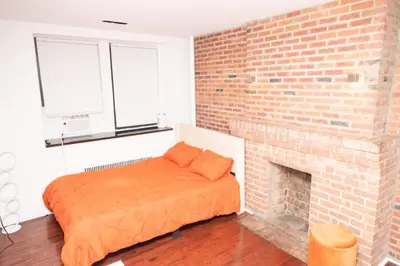 a bedroom with a brick fireplace and a bed at West Village Escape - Steps from Subway Cafes in New York