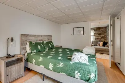 a bedroom with a green bed and a couch at Game Room, Hot Tub and Fire Pit Pocono Lake Escape! in Pocono Lake