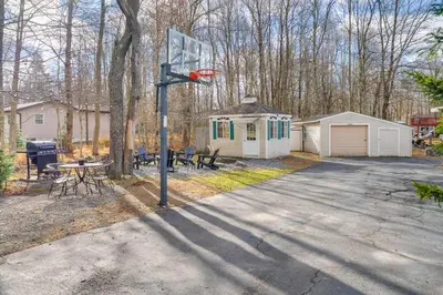 a basketball hoop in a yard with a house at Game Room, Hot Tub and Fire Pit Pocono Lake Escape! in Pocono Lake