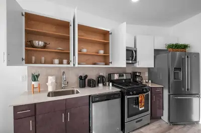 a kitchen with stainless steel appliances and wooden cabinets at Premium 1BR - Workstation Pool Balcony in Philadelphia