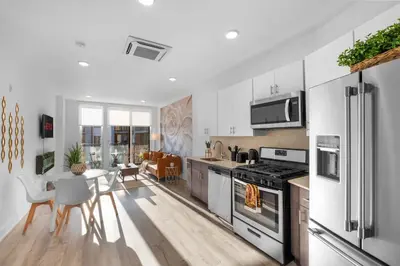 a kitchen with white appliances and a table and chairs at Premium 1BR - Workstation Pool Balcony in Philadelphia