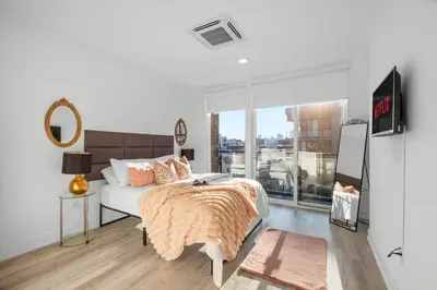a bedroom with a bed and a large window at Premium 1BR - Workstation Pool Balcony in Philadelphia