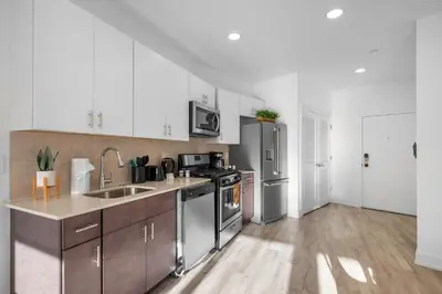 a kitchen with stainless steel appliances and wooden floors at Premium 1BR - Workstation Pool Balcony in Philadelphia