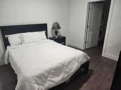 a bedroom with a large bed with a white comforter at express housing in Philadelphia