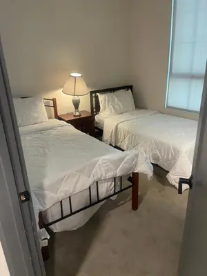 a room with two beds and a table with a lamp at express housing in Philadelphia