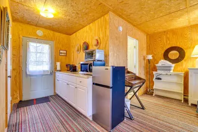 a kitchen with a refrigerator and a table in it at Hike, Ski and Golf Water-View Lake Winola Retreat! in Factoryville