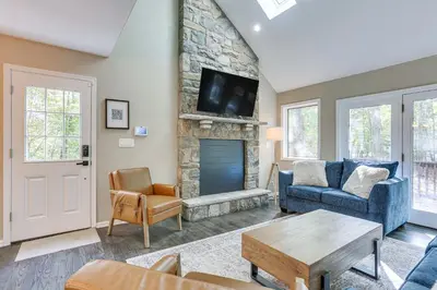 a living room with a fireplace and a tv at 6 Mi to Bushkill Falls Secluded Home with Game Room in East Stroudsburg