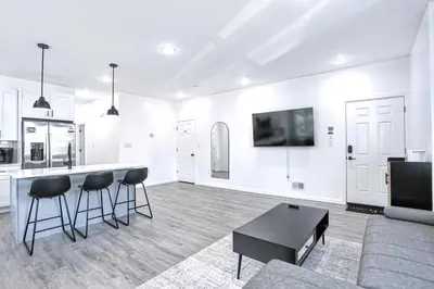 a white living room with a couch and a table at Newly Built Lake House Near NYC EWR MetLife AD Mall in Passaic