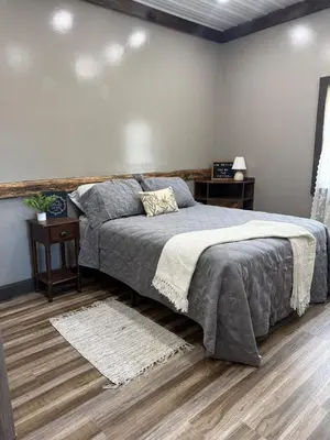 a bedroom with a large bed and a wooden floor at Rest in Wellsville