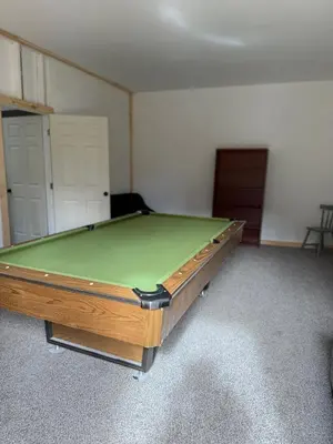 a pool table in a room with a green top at Rest in Wellsville