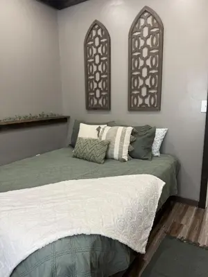 a bedroom with a bed and two windows at Rest in Wellsville