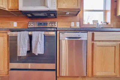 a kitchen with stainless steel appliances and wooden cabinets at Secluded Retreat near Ski Resorts, Hot Tub, BBQ in Blakeslee