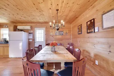 a dining room with a wooden table and a refrigerator at Secluded Retreat near Ski Resorts, Hot Tub, BBQ in Blakeslee