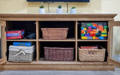 a wooden cabinet with baskets and toys in it at Lake Area 6BR Pet friendly home in Poconos - Your Pocono Retreat in Thornhurst