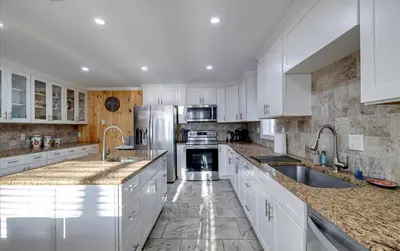 a kitchen with white cabinets and stainless steel appliances at Lake Area 6BR Pet friendly home in Poconos - Your Pocono Retreat in Thornhurst