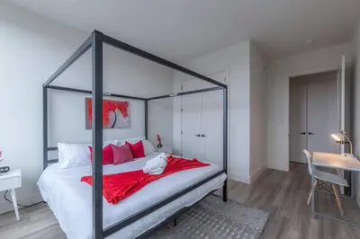 a bedroom with a black canopy bed with red pillows at Smoked Amber Stay, Free Parking, Sleep 5, 20 percent OFF in East Orange