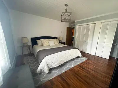 a bedroom with a bed and a wooden floor at Cozy Creek House in Forestburgh