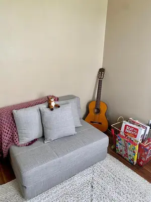 a living room with a couch and a guitar at Cozy Creek House in Forestburgh