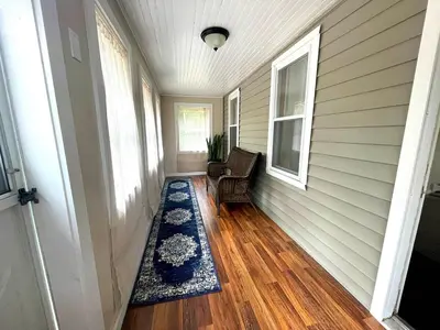 a hallway of a home with a chair and a rug at Cozy Creek House in Forestburgh