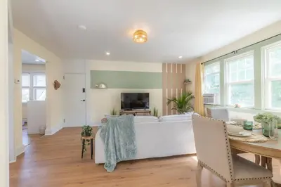 a living room with a bed and a dining table at Zen Den With King Bed and Very Close to Airport in Newark