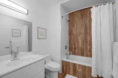 a white bathroom with a toilet and a sink at Modern 1BR Escape - Balcony Gym Wi-Fi in Philadelphia
