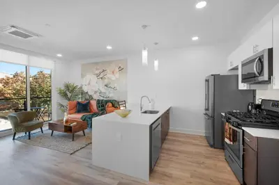 a kitchen and living room with a stove top oven at Modern 1BR Escape - Balcony Gym Wi-Fi in Philadelphia