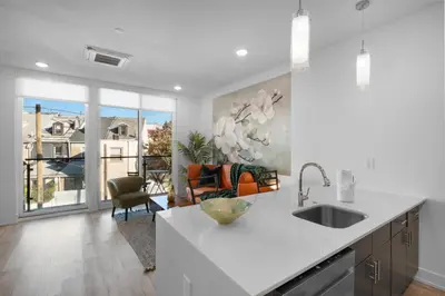 a kitchen with a sink and a living room at Modern 1BR Escape - Balcony Gym Wi-Fi in Philadelphia
